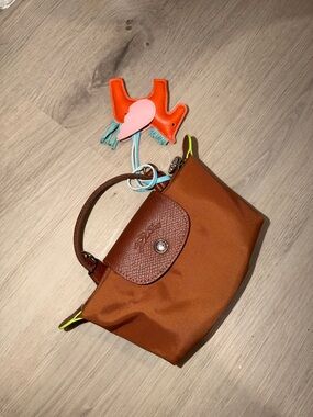 Longchamp brown Le Pliage small handbag with neon yellow trim and colorful charm